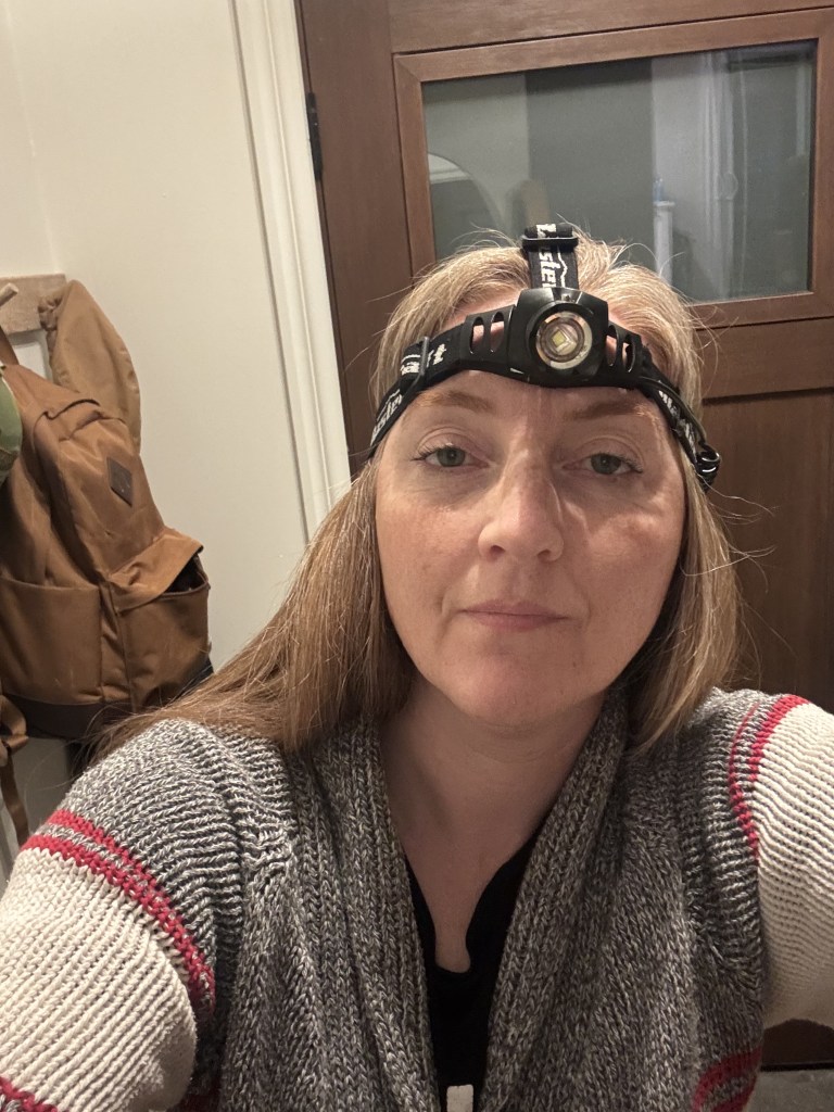 A red-headed woman inside, wearing a headlamp.